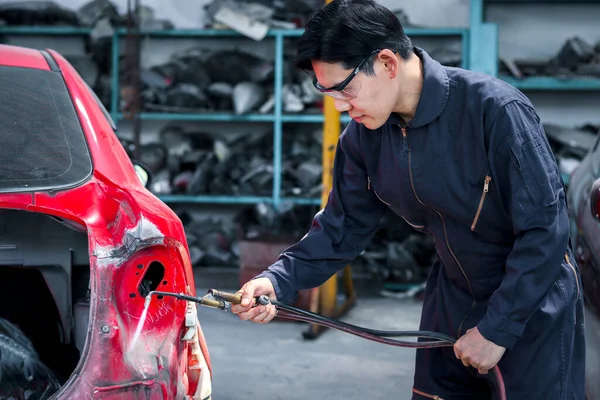 英俊的亚洲机修工在统一焊接汽车车身板车 汽车机修工修整 维修维修维修客户汽车在车库里维修服务 — 图库照片