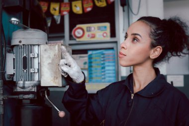 Garajda çalışırken güzel kadın tamircinin portresi, araba servisi teknisyeninin müşteri arabasını tamir etmesi, otomobil tamirhanesindeki araç motorunu denetlemesi.