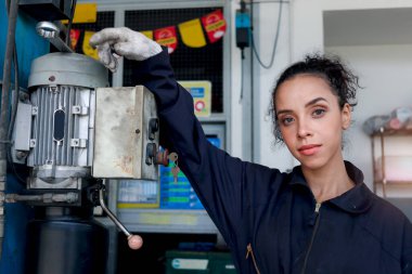 Garajda çalışan güzel kadın tamircinin portresi, araba servisi teknisyeninin müşteri arabasını tamir etmesi, otomobil tamirhanesinde araç motorunu denetlemesi..