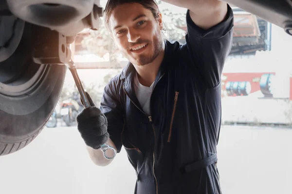 Otomobil Tamircisi Yakışıklı Adam Garajda Tekerlekleri Kontrol Ediyor Araba Servisi — Stok fotoğraf