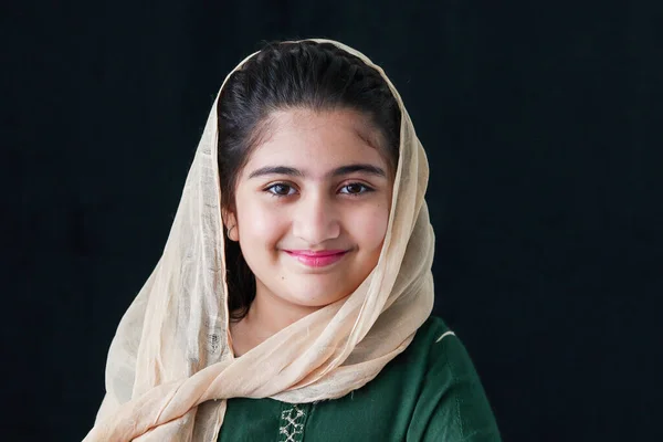 ヒジャーブと伝統衣装を着た美しい目を持つ愛らしい幸せな笑顔パキスタンのイスラム教徒の女の子 かなりかわいいですインドの子供の肖像画ともに笑顔顔上の黒の背景 — ストック写真