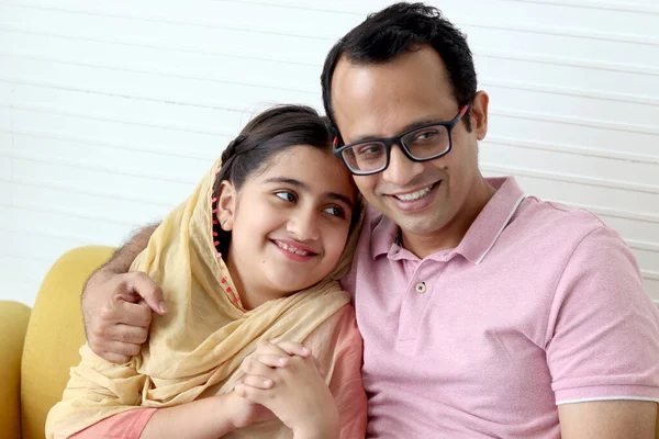 インドのイスラム教徒の娘女の子とともに伝統的なヒジャーブスカーフで座っています彼女の父でリビングルーム お父さん抱擁彼の子供 笑顔かわいい子供と一緒に過ごす時間お父さんと一緒に家で 幸せな素敵な家族 — ストック写真