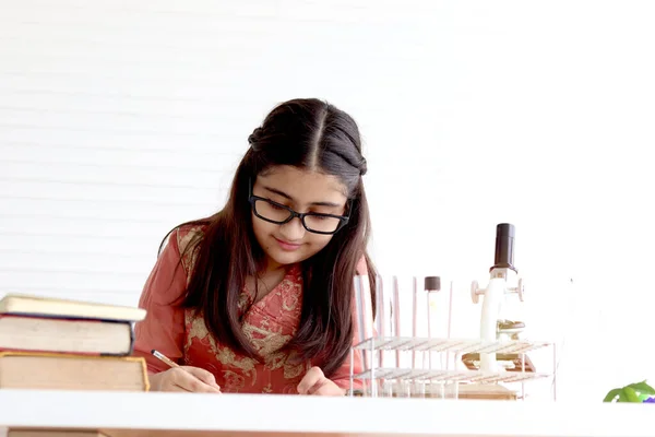 教室で生物学と化学を学ぶ顕微鏡や実験装置を持つ若い科学者の子供実験室で科学実験を行うインドの伝統的なドレスの衣装でかわいいインドの女の子 — ストック写真