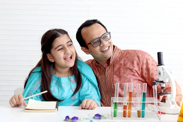 かわいいですインドの学校の女の子でインドの伝統的な衣装を着て実験室で科学実験を行う父や教師の家庭教師 若いです科学者の子供で実験室機器教室で化学を学びます — ストック写真