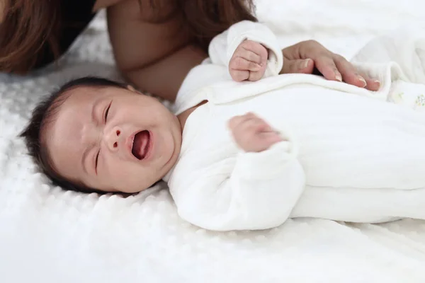 Beyaz Yatak Odasındaki Beyaz Yatağa Uzanmış Ağlayan Yeni Doğmuş Bebek — Stok fotoğraf