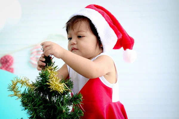 Cute Baby Girl Kid Santa Claus Czerwony Kostium Próbuje Udekorować — Zdjęcie stockowe