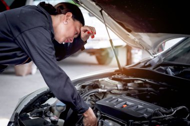 Garajda motorlu araçla çalışan güzel kadın otomobil tamircisi, otomobil tamirhanesinde müşteri arabasını kontrol eden ve tamir eden araba tamircisi,.