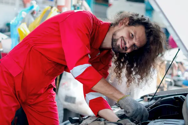 Kırmızı Üniformalı Uzun Saçlı Yakışıklı Tamirci Otomotiv Teknisyeni Garaj Araba — Stok fotoğraf