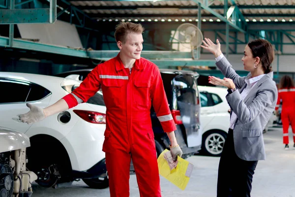 Güzel Müşteri Kadın Kırmızı Üniformalı Tamirciyle Otomobil Tamirinin Maliyetini Tartışıyor — Stok fotoğraf