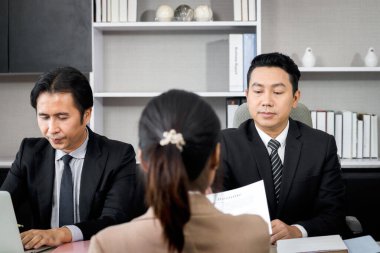 İnsan kaynakları memuru yeni bir iş arayan aday kadından özgeçmiş alıyor, iki işadamı yeni çalışanla görüşüyor, insanlar görüşme yapıyor, kariyer görüşmesi kavramı var.