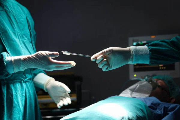 在医院手术室里 外科医生手握外科剪刀 相互传递外科设备 医疗保健和医疗专业小组 — 图库照片