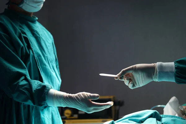 外科医生手持手术刀 在医院手术室里相互传递外科设备 外科专业小组操作外科病人 医疗及医疗概念 — 图库照片