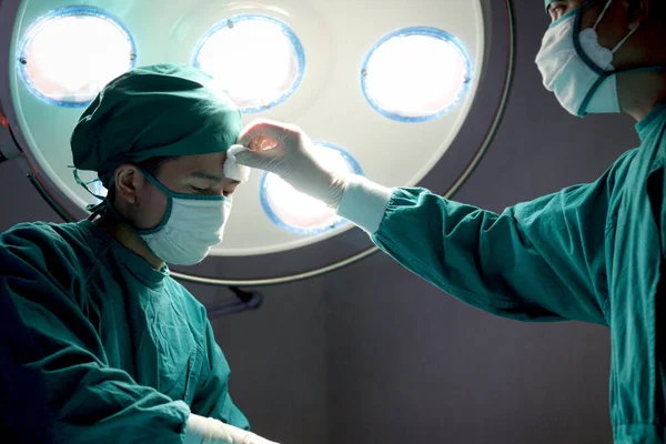Профессиональная Операционная Бригада Оперирует Пациента Медицинский Персонал Вытирает Пот Хирургу — стоковое фото