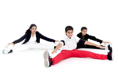 Mutlu öğrenci grubu stüdyo sınıfında modern dans eğitimi alıyor. Çocuklar, oğlanlar ve kızlar, beyaz arka planda dans ediyorlar. Üç küçük dansçı birlikte break dans yapıyor..