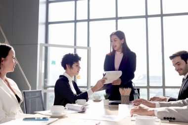 Başarılı güzel iş kadını deneyimi paylaşıyor ve konferans masasında sunum yapıyor, iş adamları iş yerinde proje çalışmaları hakkında tartışıyor, işyerinde çalışan insanlar