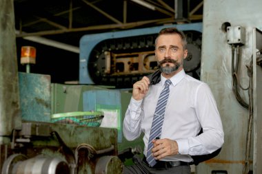Fabrika fabrikasını denetleyen kıdemli işadamının portresi. Müdür işyerini ve fabrikanın üretim sürecini denetliyor. İş sahasında endüstri bakım müdürü.