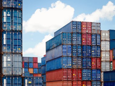 Güneşli bir günde lojistik nakliye sahasında yığınla kargo konteynırı.