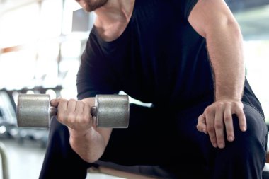 Spor salonunda halteri kaldıran güçlü, genç, kaslı bir adam. Spor adamı spor salonunda halter egzersizi yapıyor. Atletik ağırlık çalışması, sağlıklı ve mükemmel vücut geliştirme programı..