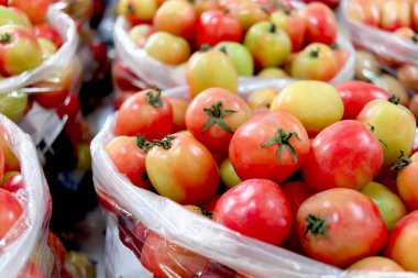 Hasattan sonra plastik poşetlerdeki domatesler, pazarda satılacak taze domatesler, seçici bir odak noktası.