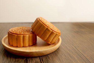Ahşap tabakta ay çöreği, ahşap masada Çin usulü ay çöreği. Sonbahar ortası kutlaması, Mutlu Çince çevirisi Sonbahar Festivali.