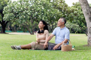 Mutlu aile, yaşlı Asyalı adam ve güzel kız yeşil yaz bahçesinde piknik yapıyorlar. Büyükbabam dışarıda torunuyla birlikte parkta vakit geçirir. Bakıcıyla dışarı çık..