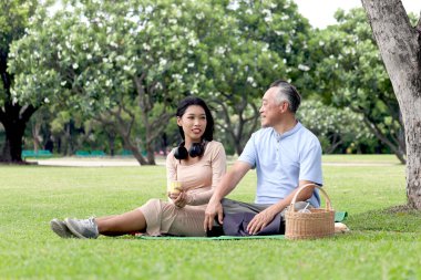 Mutlu aile, yaşlı Asyalı adam ve güzel kız yeşil yaz bahçesinde piknik yapıyorlar. Büyükbabam dışarıda torunuyla birlikte parkta vakit geçirir. Bakıcıyla dışarı çık..