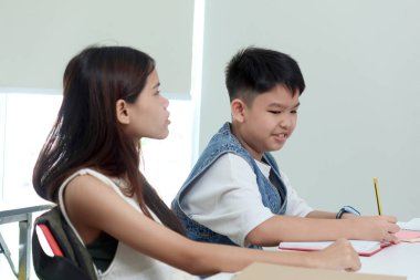 Asyalı liseli kız ve öğrenci sınıflarda birlikte okuyorlar. İlkokul çocukları okulda okuyorlar. Mutlu bir öğrenci okulda arkadaşlarıyla vakit geçirir. Çocuk ve eğitim