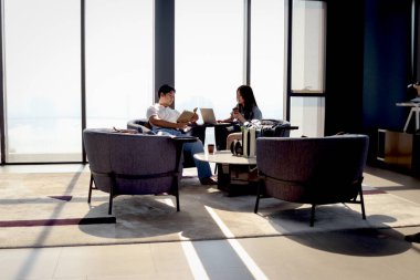 Genç Asyalı çift evlerinde birlikte vakit geçiriyorlar. Mutlu aşıklar kitap okuyor ve oturma odasında kahve içiyor. İnsanlar en sevdikleri aktivitelerle zaman geçirirler.