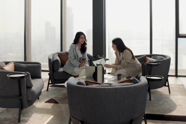 Modern ofiste birlikte çalışmayı tartışan iki güzel iş kadını. İş yerinde çalışan kadın iş adamları. İş adamları iş yerinde toplantı yapıyorlar..