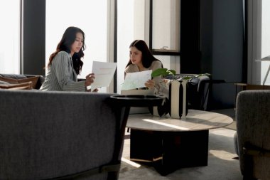 Modern ofiste birlikte çalışmayı tartışan iki güzel iş kadını. İş yerinde çalışan kadın iş adamları. İş adamları iş yerinde toplantı yapıyorlar..