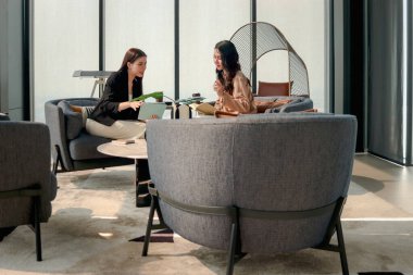 Modern ofiste birlikte çalışmayı tartışan iki güzel iş kadını. İş yerinde çalışan kadın iş adamları. İş adamları iş yerinde toplantı yapıyorlar..