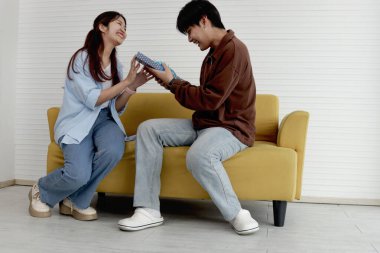 Genç bir kadın erkek arkadaşına hediye paketi veriyor. Oturma odasında kanepede otururken yıldönümünü kutlamak için. Adam şimdiki zamana bakar, şaşırır. Mutlu Asyalı sevgili çifti kutluyoruz.