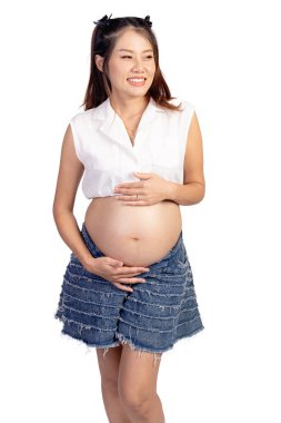 Mutlu gülümseyen Asyalı hamile kadının portresi. Beyaz arka planda karnı soyutlanmış bir anne. Hamile anne karnına hafifçe dokunuyor. Koca göbekli hamile bir kadın. Mutlu aile