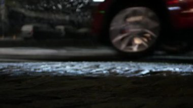 Kar yağışı sırasında karla kaplı bir yolda arabaların yanından geçmek. Yakın çekim, çerçevede yolu ve geçen arabaların tekerleklerini görebilirsiniz..