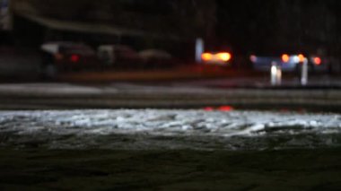 Şiddetli trafik ışıkları olan, kar yağarken karanlık sokaklar. Bütün yol gri kirli karla kaplı..