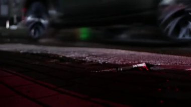 Yol kenarındaki kaldırımdan ateş edilmiş. Çerçevede, arabaların hareketi, tekerleklerin manzarası..