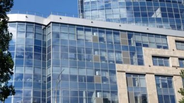 Açık bir yaz gününde yüksek camdan bir gökdelene ateş etmek. Duvarlar kare pencere sektörlerinden oluşuyor.