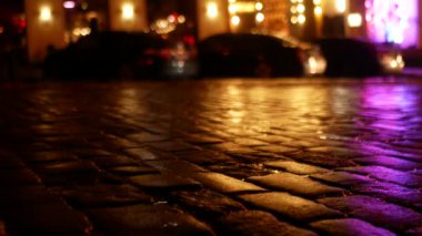 Akşamları kaldırım taşları ve restoranlarla ıslak şehir caddesi. Büyük bir şehrin aktif şehir hayatı.