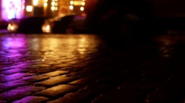 Yağmur altında kaldırım taşlarından yola çıkan araçların aktif hareketi. Geceleri zemin katta çekim yapmak..