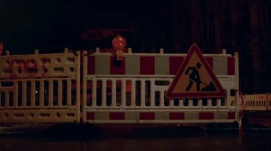 Yanımızdan geçen arabalar tamiratın çitlerini aydınlatıyor. Çitteki fener yanıp sönüyor ve bir sapma uyarısı yapıyor..