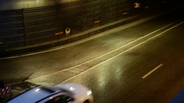 雨の後 光沢のある道路に沿って1人の乗用車のドライブ トンネルの壁は落書きで覆われた段ボールで覆われています — ストック動画