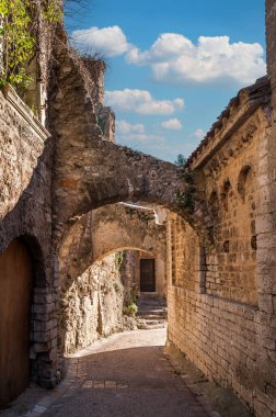 Fransa 'nın Occitanie kentindeki Saint-Guilhem-le-çölünde dar bir sokak.