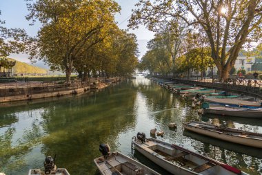 Quai Jules Philippe, Fransa 'nın Haute Savoie kentindeki Annecy Gölü' nde ve ağaçların gölgesinde bir kanal.