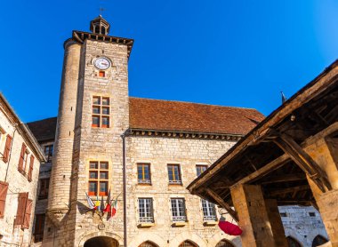 The Place de la Halle and clock tower, in Martel, in the Lot, in Occitanie, France clipart