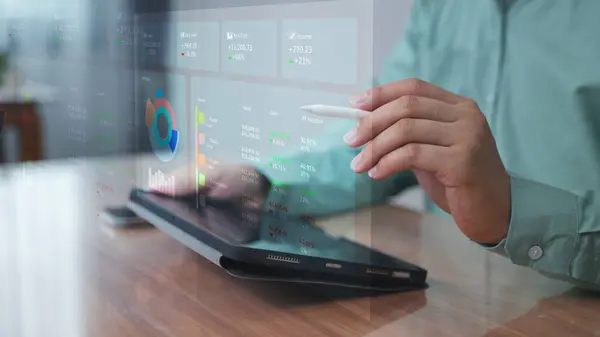 Sanal gösterge paneli ve grafikli dizüstü bilgisayar kullanan profesyonel dijital iş yerinde veri görselleştirme ve performans izleme kavramı.