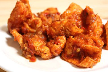 Fried Pork Skins With Red Salsa on Wooden Table in Rustic Kitchen