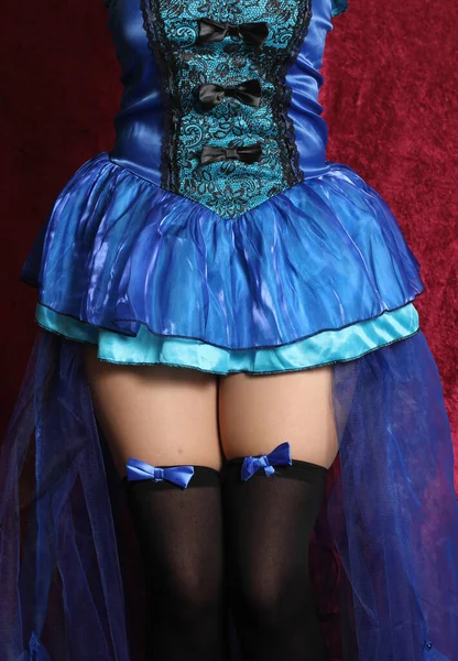 レッドベルベットの背景にブルーの髪とブルーのコルセットドレスを持つ女性 — ストック写真