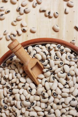 Tahta masadaki kasede pişmemiş siyah göz bezelyeleri.