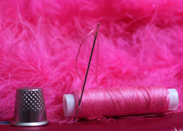 复古粉红缎子和羽毛织物上的粉红线和顶针片 — 图库照片