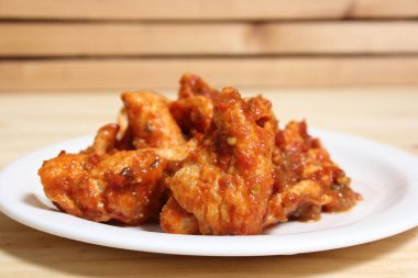 Fried Pork Skins With Red Salsa on Wooden Table in Rustic Kitchen